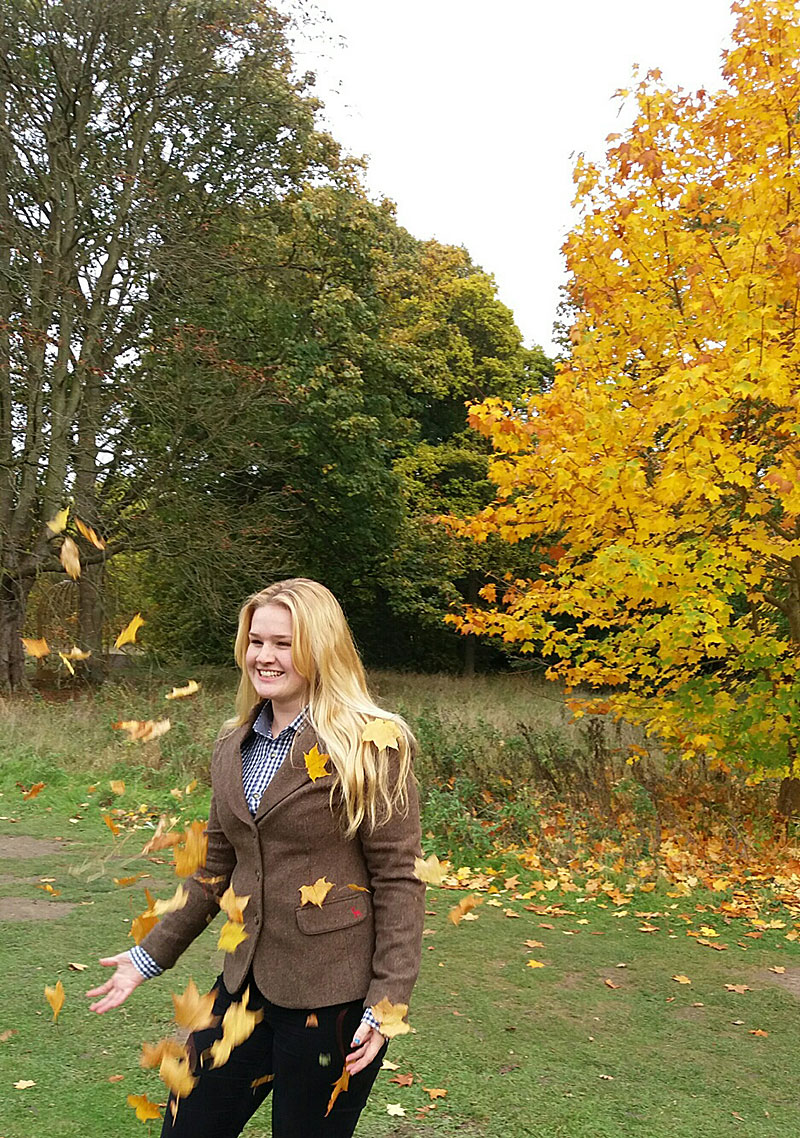 Jess in the Autumn throwing leaves